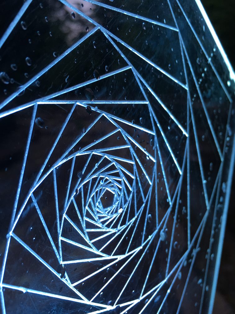 Close-up of an illuminated blue acrylic spiral