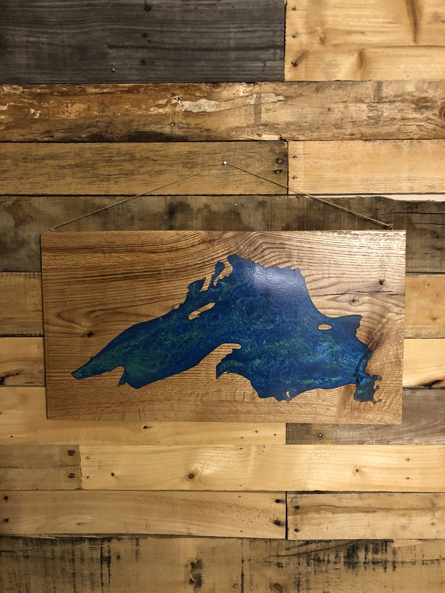 Blue-green resin lake silhouette in a wood panel