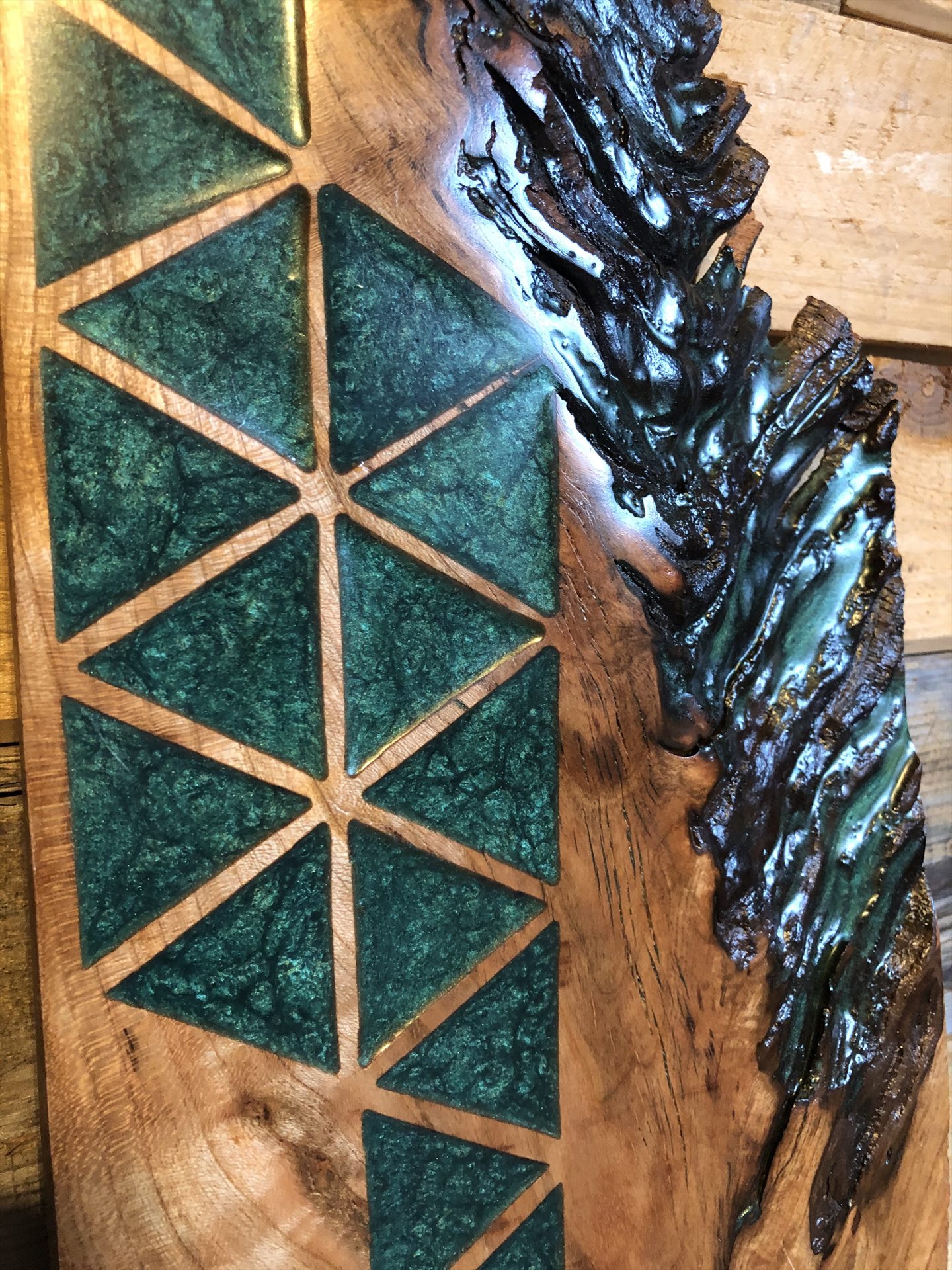 Green resin geometric inlay set into a natural-edge wood panel