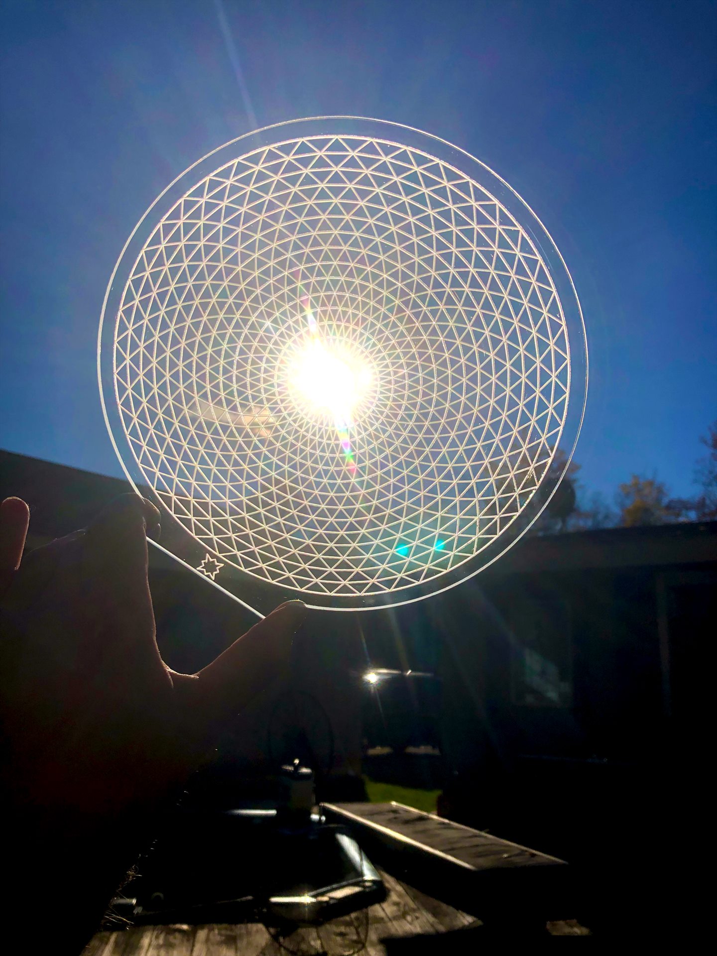 Circular acrylic triangular lattice held in front of the sun