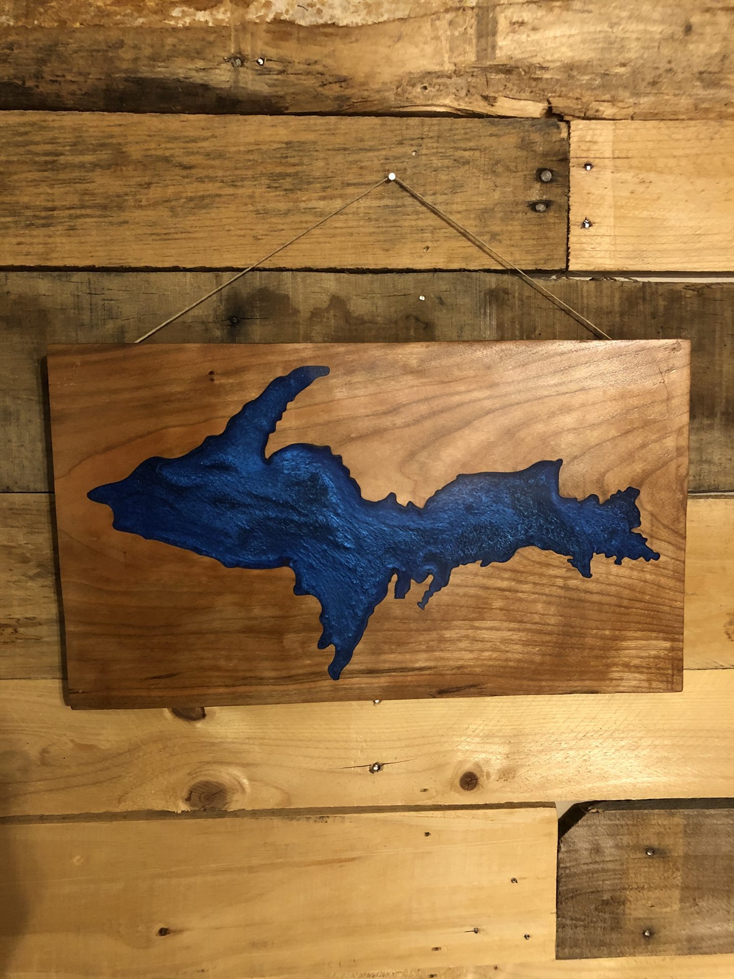 Blue resin silhouette of Michigan's Upper Peninsula in wood