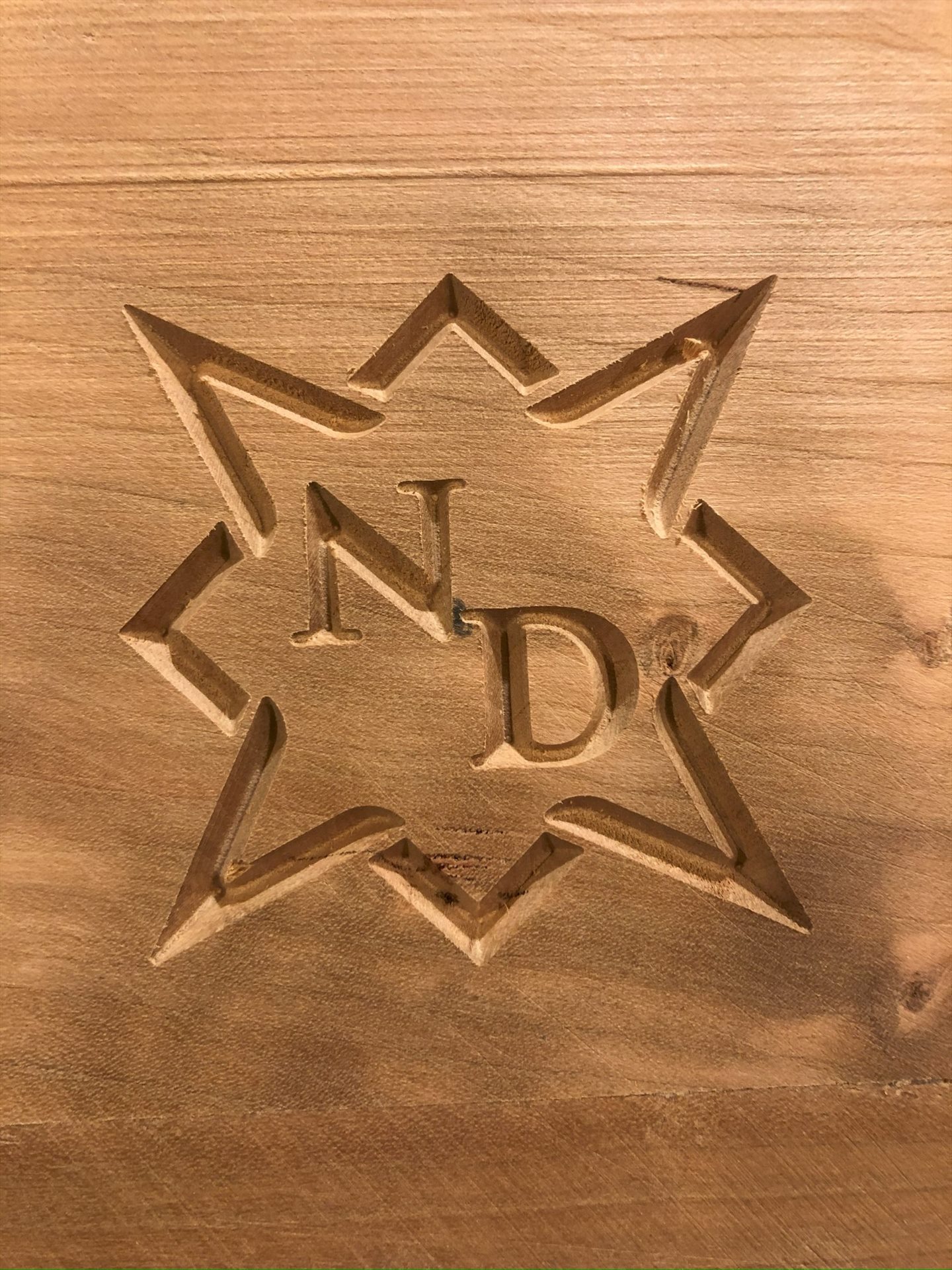Nagy Design initials and geometric mark carved into wood